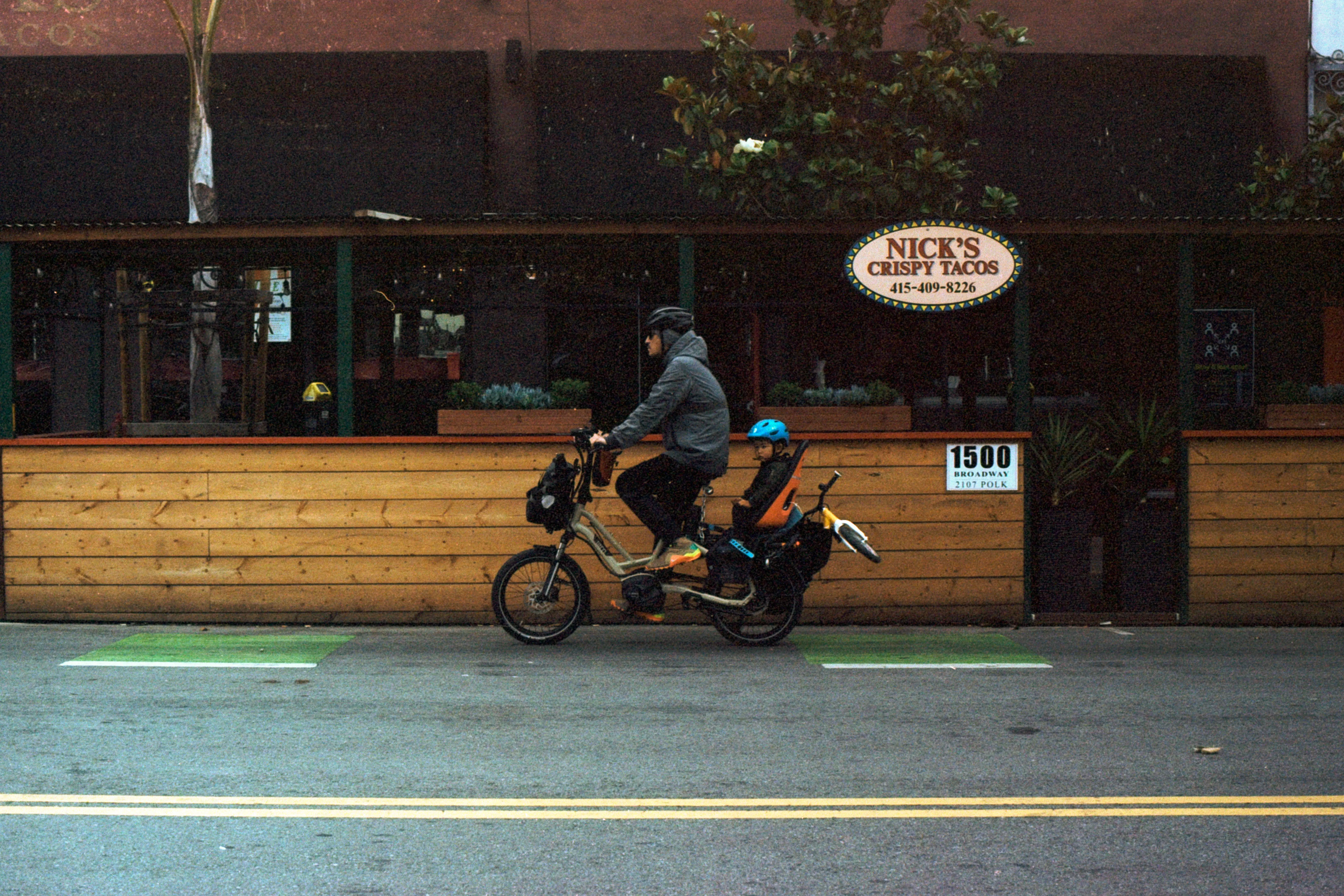 A man biking with his kid.