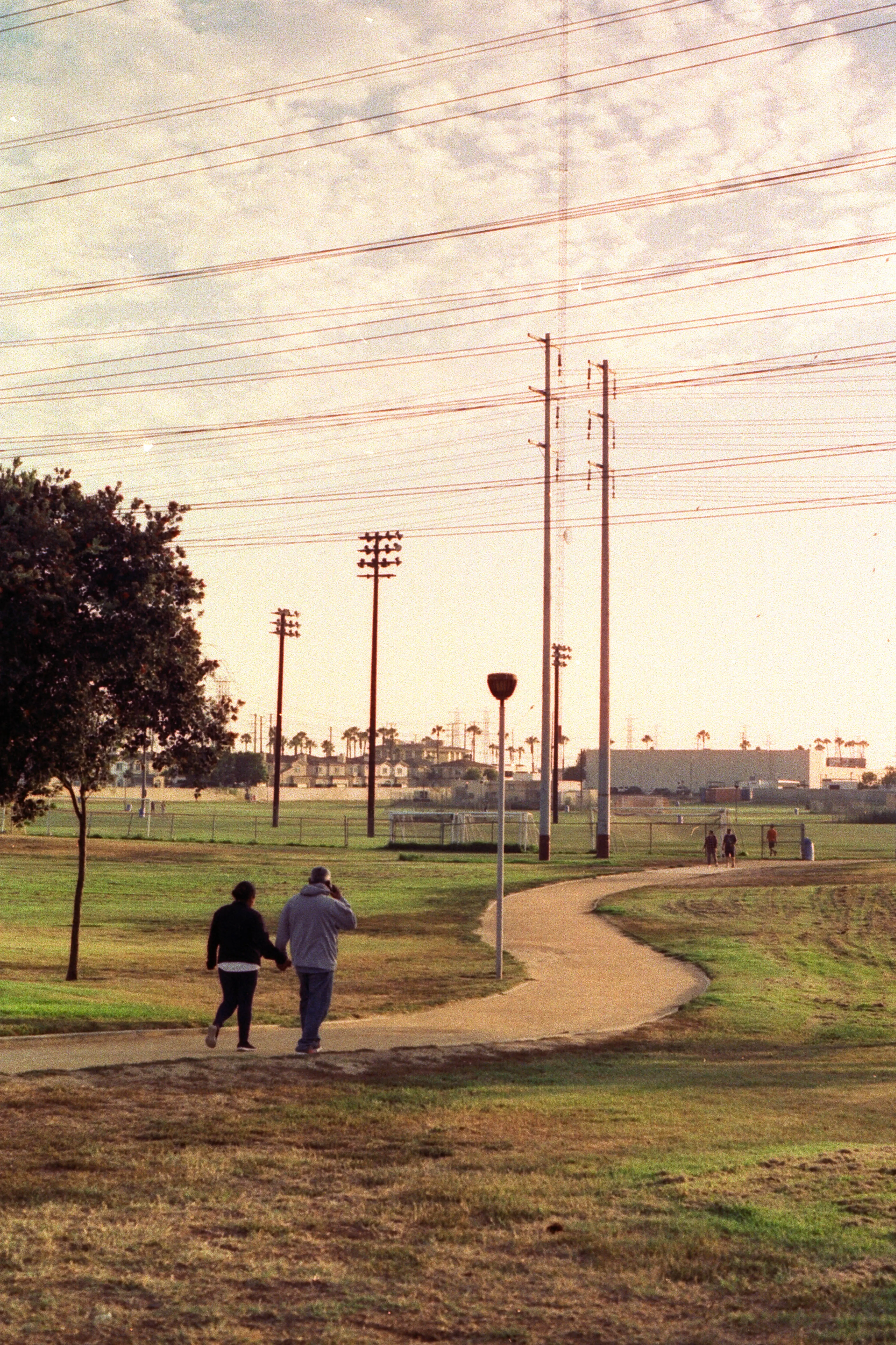 A couple walking in the park while the sun is setting.