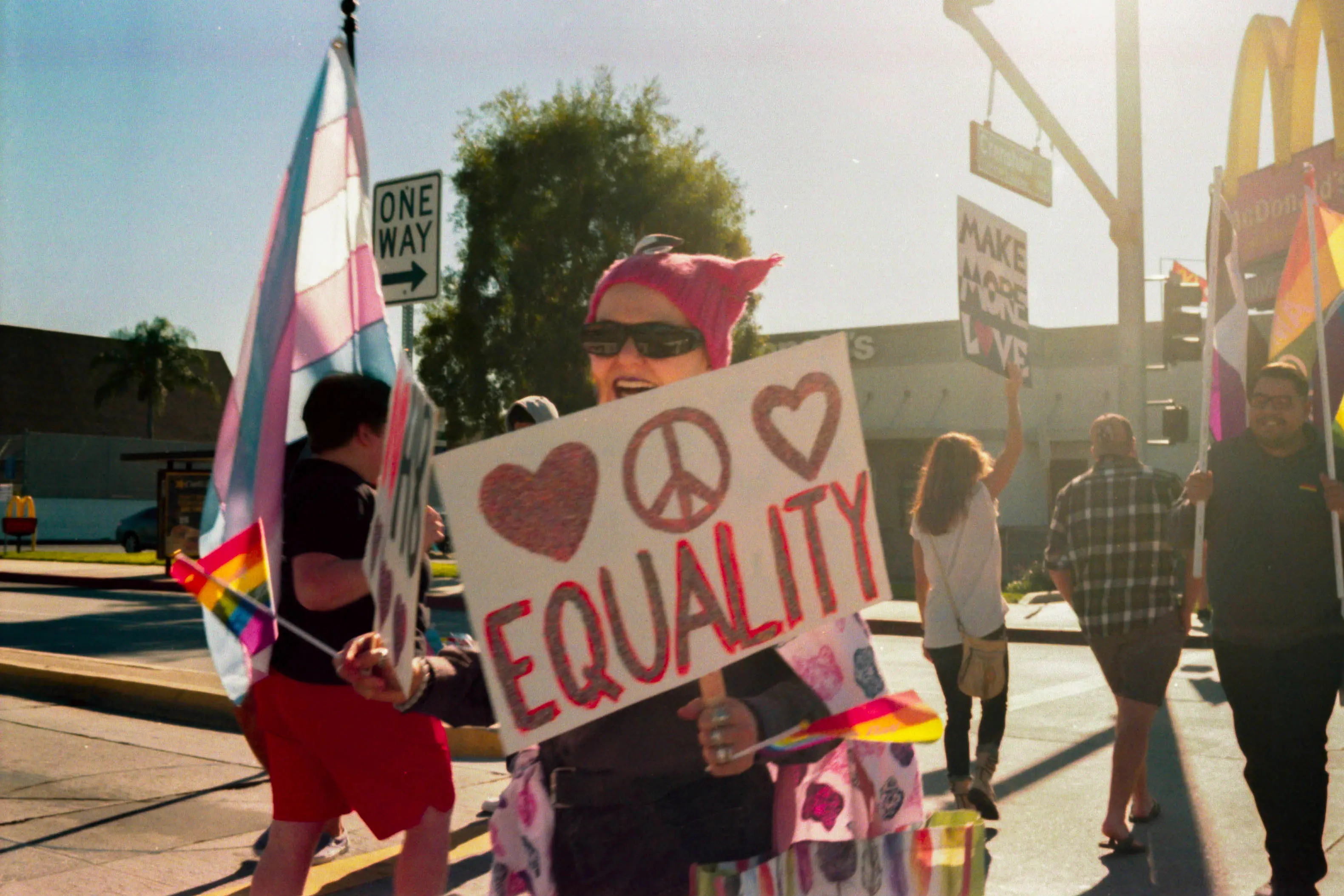 A photo of an enderly woman holding up a sign that says "EQUALITY"