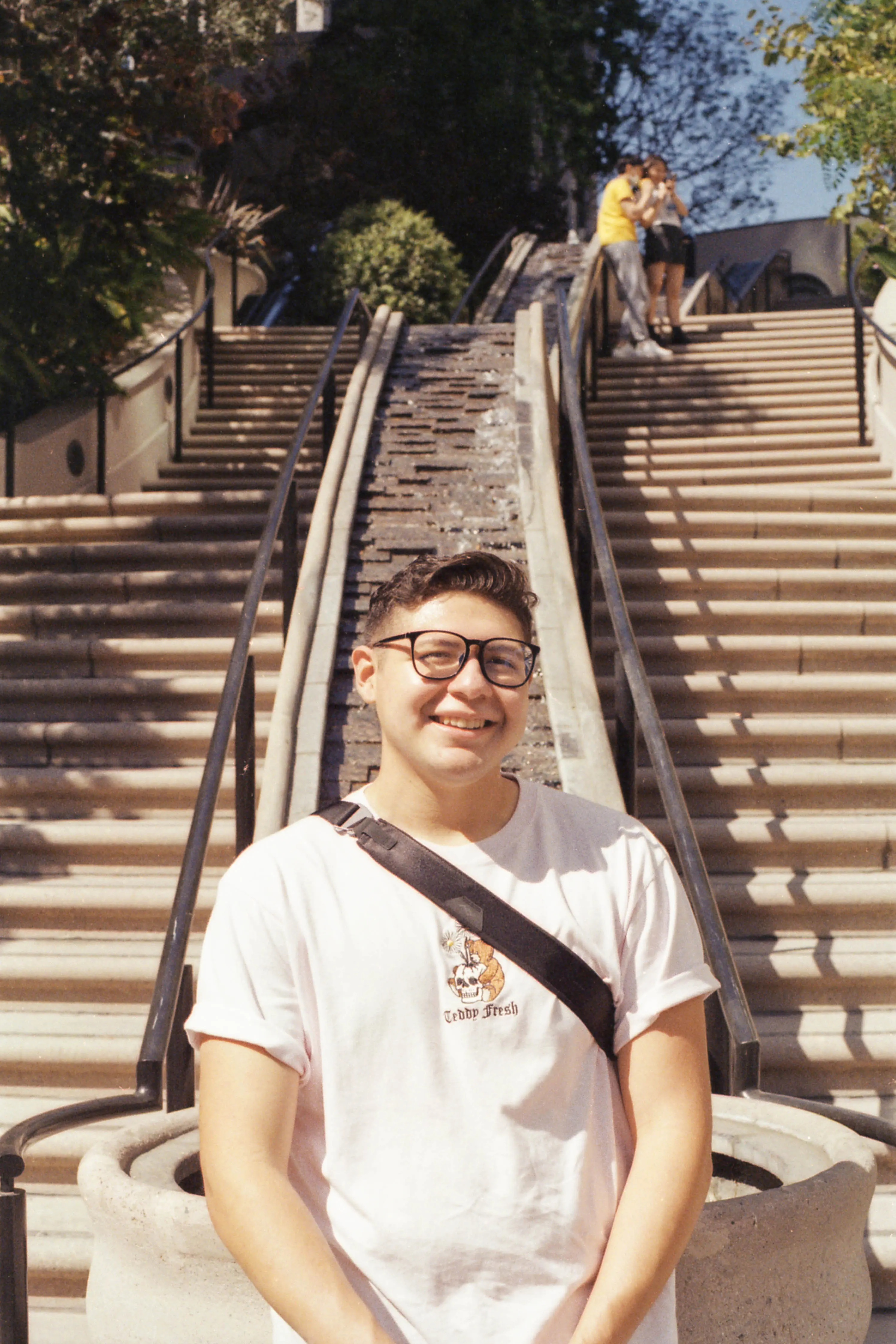 A man sitting against a rail, smiling